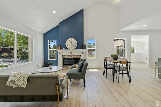 905 N 100 E, Pleasant Grove, UT 84062 - living area featuring high vaulted ceiling, a tiled fireplace, light wood-style flooring, baseboards, and recessed lighting