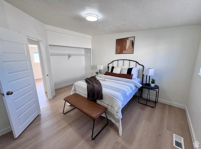 5011 S Leisure Ln W, Taylorsville, UT 84129 - bedroom with a textured ceiling, light wood finished floors, baseboards, and a closet