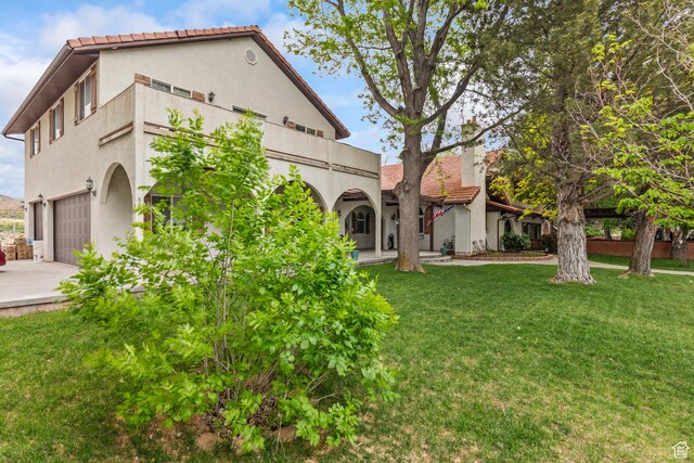 154 E 950 N, Glenwood, UT 84730 - back of property featuring stucco siding, a lawn, a tiled roof, a garage, and a balcony