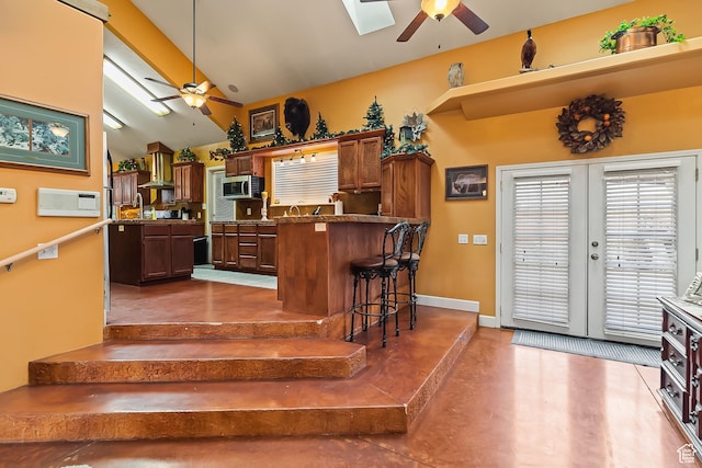 154 E 950 N, Glenwood, UT 84730 - kitchen featuring a ceiling fan, a peninsula, lofted ceiling, a kitchen bar, and stainless steel microwave