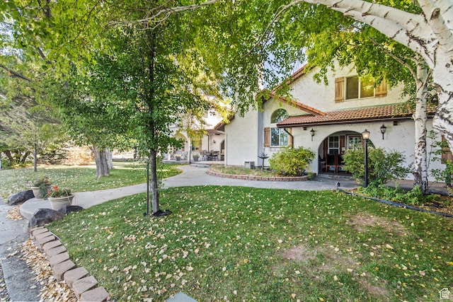 154 E 950 N, Glenwood, UT 84730 - view of front of property with stucco siding, a front lawn, and a tiled roof