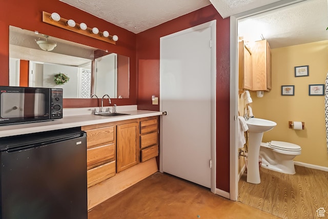 154 E 950 N, Glenwood, UT 84730 - bathroom featuring a sink, a textured ceiling, toilet, and baseboards