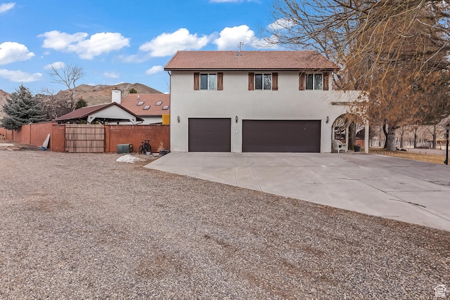 154 E 950 N, Glenwood, UT 84730 - view of front of house featuring a garage, stucco siding, concrete driveway, and a tiled roof