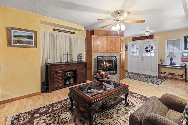 154 E 950 N, Glenwood, UT 84730 - living room with light wood-style floors, a warm lit fireplace, ceiling fan, and baseboards