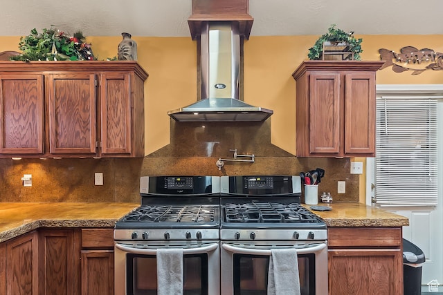 154 E 950 N, Glenwood, UT 84730 - kitchen featuring stainless steel gas range oven, exhaust hood, decorative backsplash, and brown cabinets