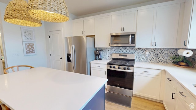 9367 N Vernham Way E, Eagle Mountain, UT 84005 - kitchen featuring appliances with stainless steel finishes, light countertops, backsplash, a kitchen island, and white cabinetry