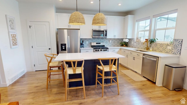 9367 N Vernham Way E, Eagle Mountain, UT 84005 - kitchen featuring stainless steel appliances, a sink, backsplash, a kitchen breakfast bar, and white cabinets