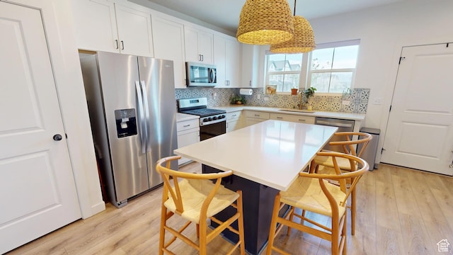 9367 N Vernham Way E, Eagle Mountain, UT 84005 - kitchen with stainless steel appliances, light wood finished floors, a breakfast bar area, and tasteful backsplash