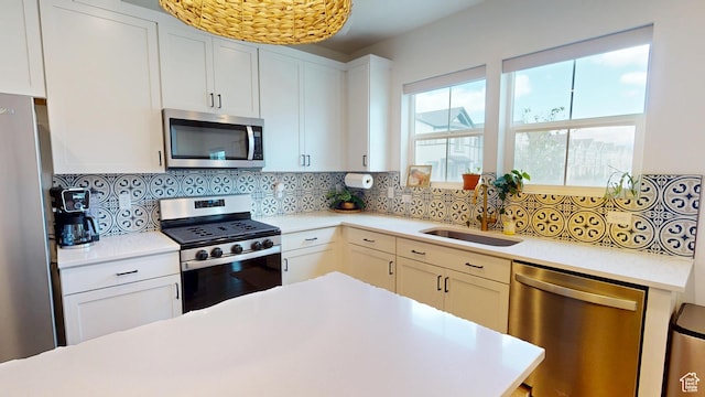 9367 N Vernham Way E, Eagle Mountain, UT 84005 - kitchen featuring appliances with stainless steel finishes, a sink, light countertops, decorative backsplash, and white cabinetry