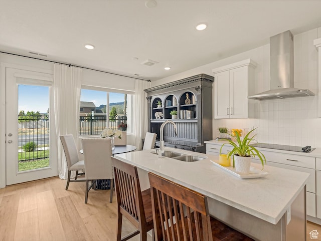 1512 W Fiore St, Farmington, UT 84025 - kitchen with a sink, wall chimney range hood, black electric stovetop, a center island with sink, and white cabinets