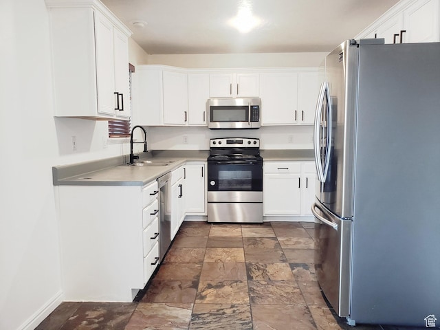 4142 S Davencrest Ln, Taylorsville, UT 84129 - kitchen featuring stainless steel appliances, a sink, dark stone finish floors, white cabinets, and light countertops