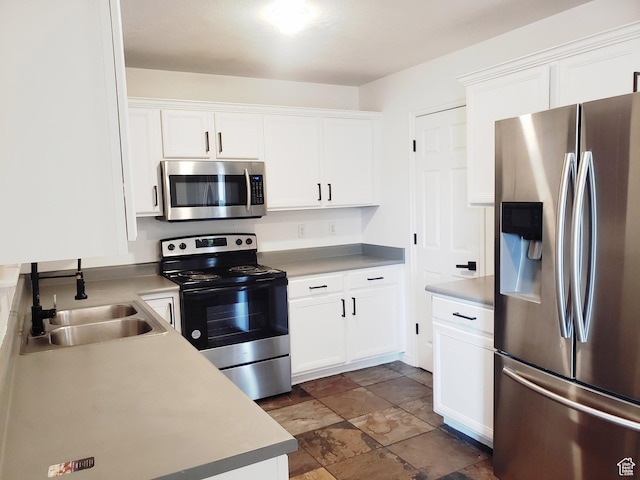 4142 S Davencrest Ln, Taylorsville, UT 84129 - kitchen with appliances with stainless steel finishes, a sink, white cabinets, light countertops, and dark stone finish floors