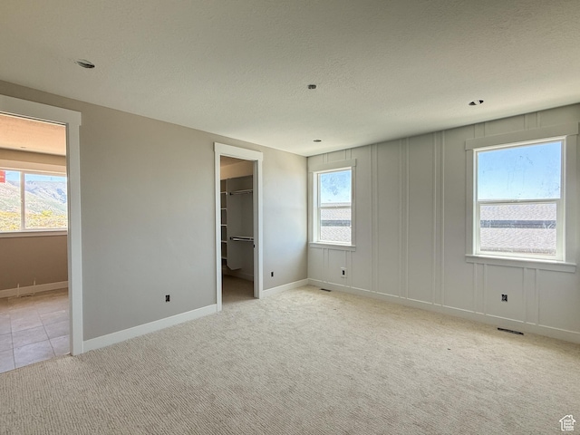 4280 N 100 E, North Ogden, UT 84414 - unfurnished bedroom featuring a textured ceiling, light carpet, a spacious closet, baseboards, and a closet