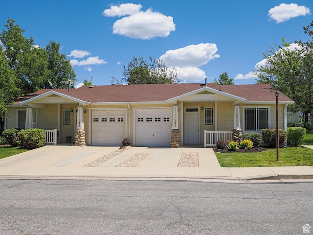 130 Bamberger Rd, North Salt Lake, UT 84054 - view of front facade featuring a porch, an attached garage, driveway, and a front lawn