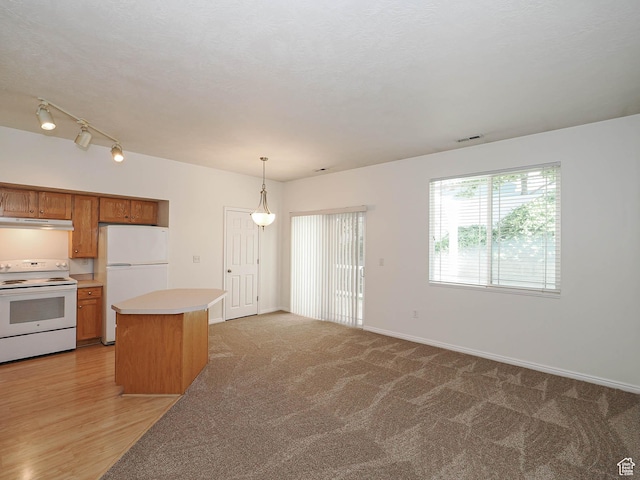 130 Bamberger Rd, North Salt Lake, UT 84054 - kitchen featuring white appliances, under cabinet range hood, light countertops, a kitchen island, and decorative light fixtures