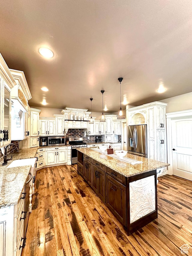 1471 N 3500 E, Ballard, UT 84066 - kitchen featuring stainless steel appliances, dark brown cabinetry, hardwood / wood-style floors, a spacious island, and a sink