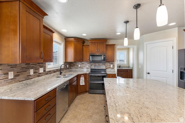13695 Highlander Cir, Beaverdam, UT 84306 - kitchen featuring appliances with stainless steel finishes, a sink, brown cabinets, backsplash, and light stone counters