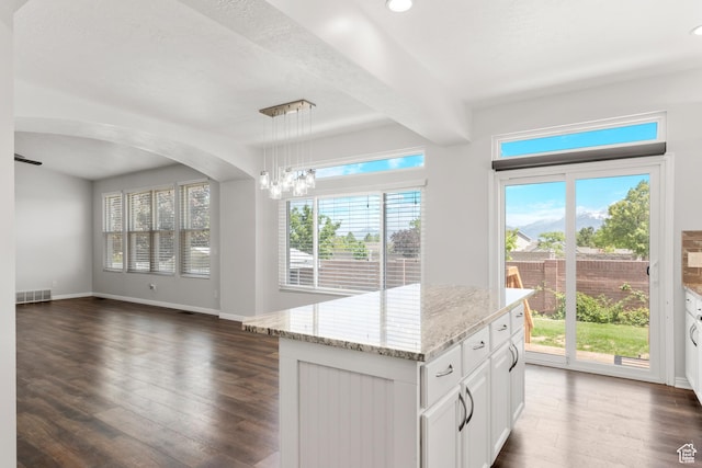 8793 S Mountain Vista Dr, West Jordan, UT 84081 - kitchen featuring dark wood-style flooring, light stone countertops, open floor plan, pendant lighting, and white cabinetry