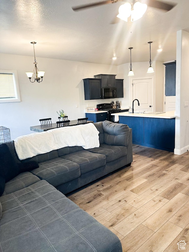 404 W 1325 N Unit L5, Cedar City, UT 84721 - living room featuring light wood-type flooring, a ceiling fan, and a chandelier