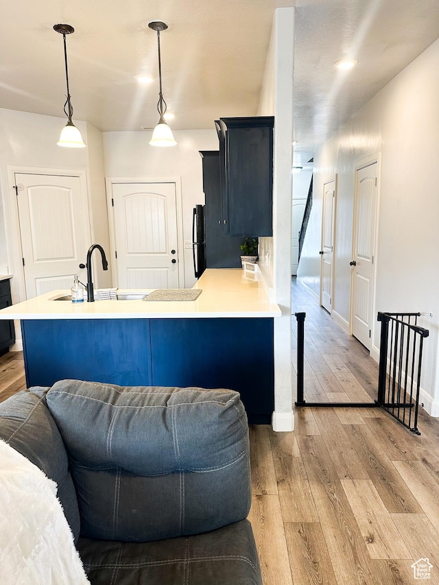 404 W 1325 N Unit L5, Cedar City, UT 84721 - kitchen with light wood finished floors, freestanding refrigerator, light countertops, and pendant lighting