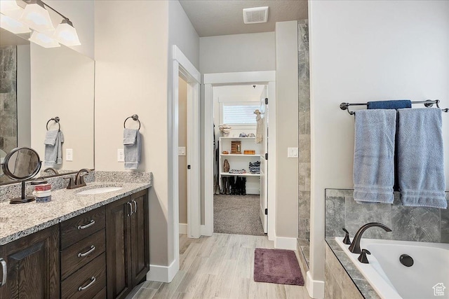 4548 N Sheep Creek Dr, Eden, UT 84310 - full bathroom featuring vanity, a bath, wood finished floors, and baseboards