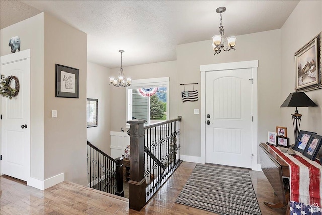 4548 N Sheep Creek Dr, Eden, UT 84310 - foyer entrance with a chandelier, wood finished floors, baseboards, and a textured ceiling