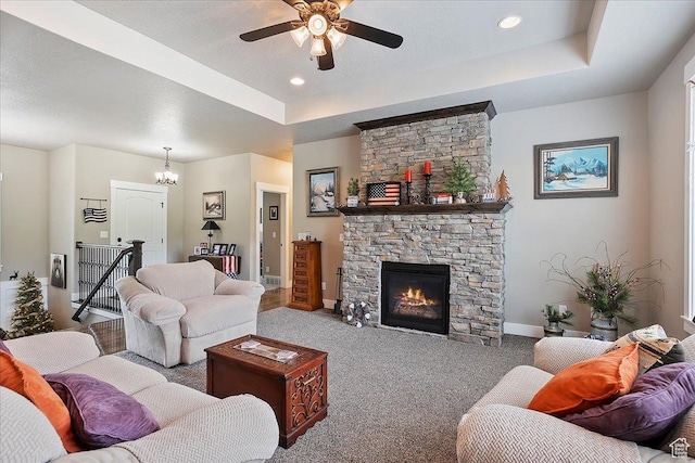 4548 N Sheep Creek Dr, Eden, UT 84310 - carpeted living room featuring a raised ceiling, baseboards, a ceiling fan, a stone fireplace, and a chandelier