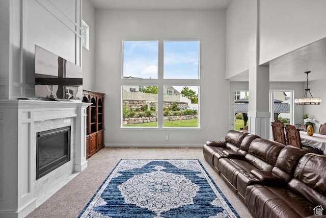 1407 W Fort Rock Dr, Saratoga Springs, UT 84045 - living room with light colored carpet, healthy amount of natural light, a premium fireplace, a high ceiling, and a chandelier