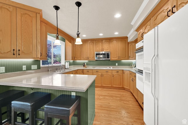 6782 S Courtland Ave, Cottonwood Heights, UT 84121 - kitchen featuring white appliances, a peninsula, light wood-type flooring, a breakfast bar area, and recessed lighting