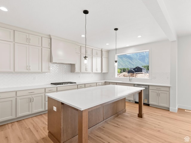 1002 E 400 N Unit 3, Salem, UT 84653 - kitchen featuring dishwasher, light wood finished floors, premium range hood, tasteful backsplash, and light countertops