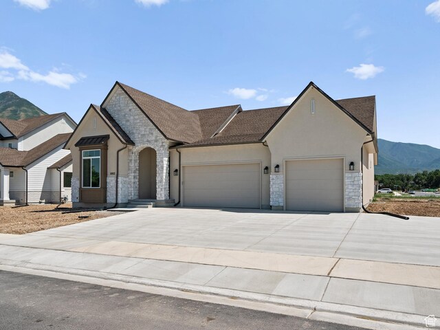 1002 E 400 N Unit 3, Salem, UT 84653 - view of front of home featuring stone siding, a garage, driveway, stucco siding, and a mountain view