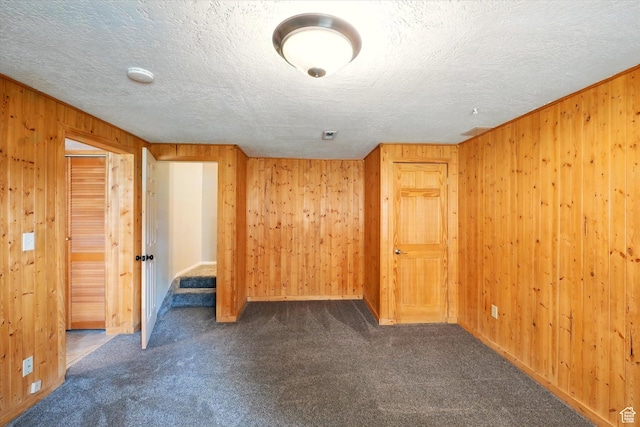 425 E 1200 N, Logan, UT 84341 - unfurnished room with wooden walls, dark carpet, a smoke detector, and a textured ceiling