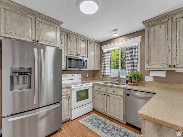 5472 Ardennes Way, Stansbury Park, UT 84074 - kitchen featuring stainless steel appliances, a sink, light countertops, and light wood-style floors