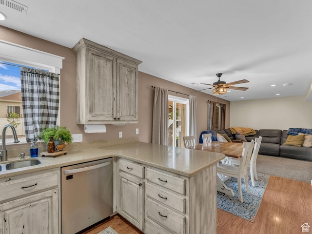 5472 Ardennes Way, Stansbury Park, UT 84074 - kitchen featuring dishwasher, a sink, open floor plan, a peninsula, and light wood-style floors