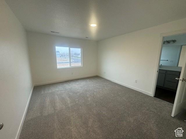 436 W Sapphire Dr Unit 7013, Tooele, UT 84074 - unfurnished bedroom with carpet flooring, baseboards, and connected bathroom