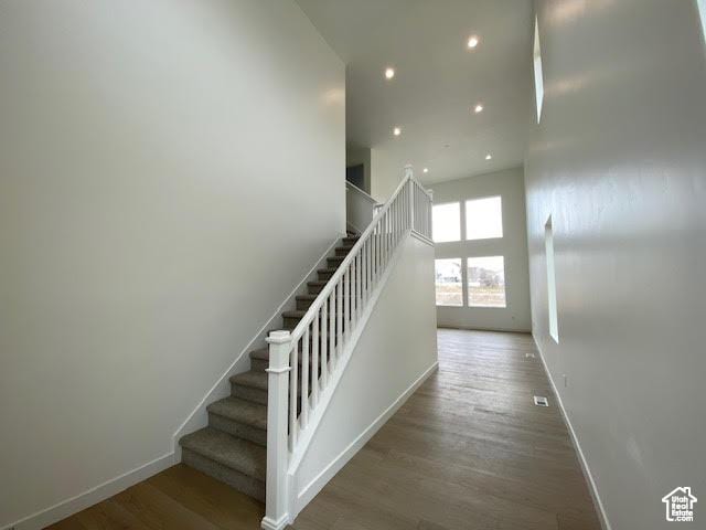 436 W Sapphire Dr Unit 7013, Tooele, UT 84074 - stairway with baseboards, wood finished floors, recessed lighting, and a towering ceiling