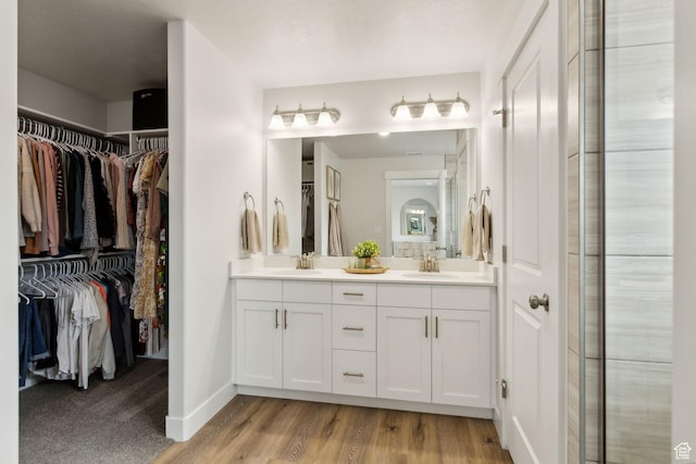 7936 N Bristlecone Rd, Eagle Mountain, UT 84005 - bathroom with double vanity, wood finished floors, a spacious closet, and baseboards
