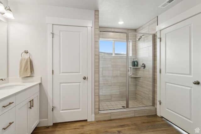 7936 N Bristlecone Rd, Eagle Mountain, UT 84005 - bathroom with vanity, a shower stall, wood finished floors, and recessed lighting