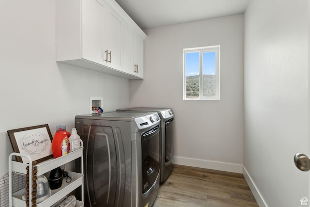 7936 N Bristlecone Rd, Eagle Mountain, UT 84005 - laundry area featuring washing machine and clothes dryer, cabinet space, baseboards, and light wood-type flooring