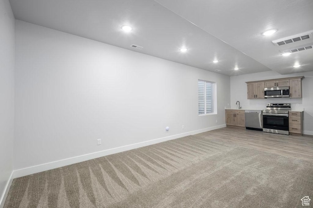 7936 N Bristlecone Rd, Eagle Mountain, UT 84005 - unfurnished living room featuring light colored carpet, baseboards, recessed lighting, and a sink