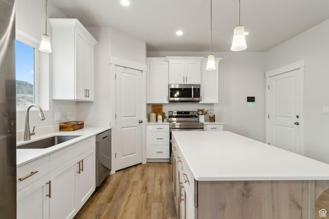 7936 N Bristlecone Rd, Eagle Mountain, UT 84005 - kitchen with appliances with stainless steel finishes, a sink, light wood-type flooring, a center island, and recessed lighting