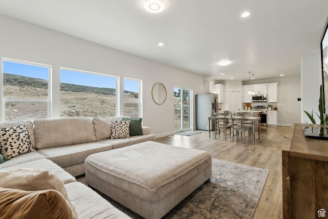 7936 N Bristlecone Rd, Eagle Mountain, UT 84005 - living area featuring light wood-style floors, baseboards, and recessed lighting