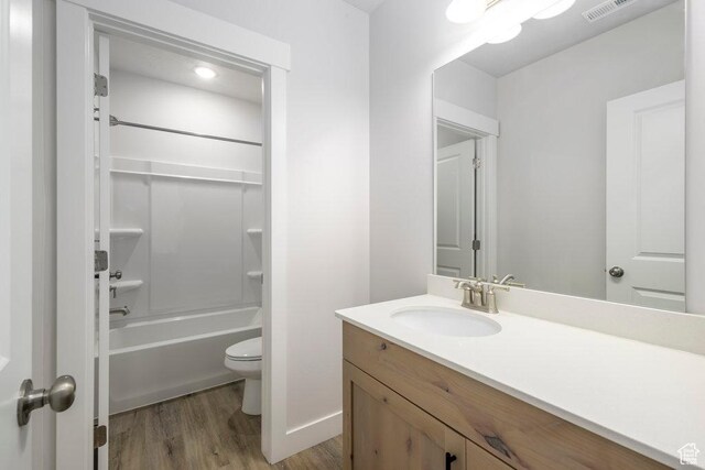 7936 N Bristlecone Rd, Eagle Mountain, UT 84005 - bathroom with vanity, wood finished floors, toilet,  shower combination, and baseboards