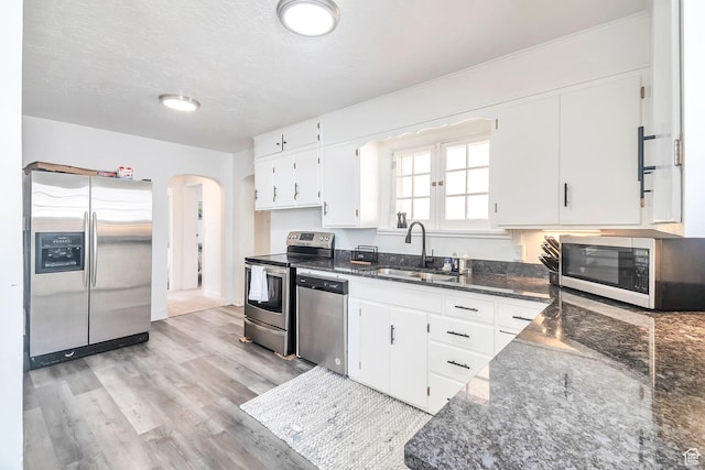 185 N 200 W, Delta, UT 84624 - kitchen featuring stainless steel appliances, a sink, arched walkways, white cabinetry, and light wood finished floors