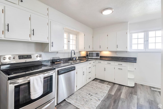 185 N 200 W, Delta, UT 84624 - kitchen with stainless steel appliances, a sink, healthy amount of natural light, white cabinets, and a textured ceiling