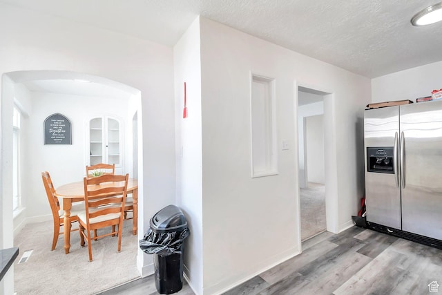185 N 200 W, Delta, UT 84624 - kitchen featuring stainless steel refrigerator with ice dispenser, wood finished floors, arched walkways, a textured ceiling, and baseboards