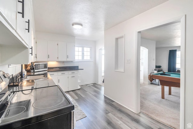 185 N 200 W, Delta, UT 84624 - kitchen with black range with electric stovetop, stainless steel microwave, white cabinets, a textured ceiling, and billiards table
