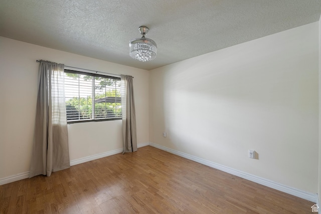 191 E Spencer Peak Way Unit I2, Draper, UT 84020 - spare room featuring a chandelier, light wood-style floors, a textured ceiling, and baseboards
