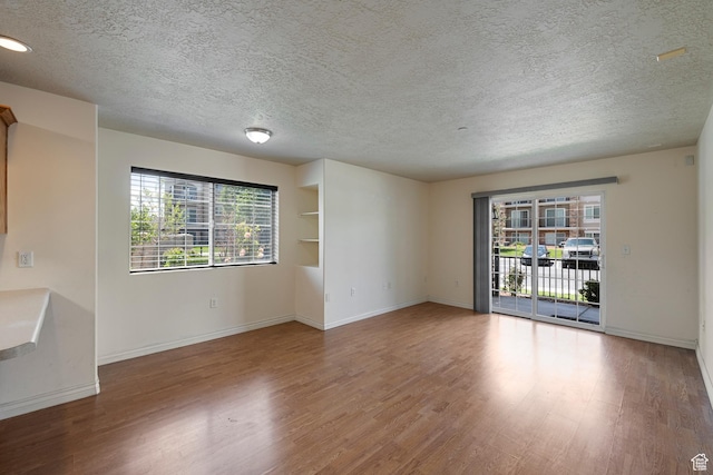 191 E Spencer Peak Way Unit I2, Draper, UT 84020 - empty room with wood finished floors, healthy amount of natural light, a textured ceiling, and baseboards