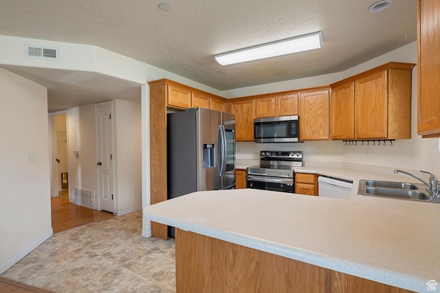 191 E Spencer Peak Way Unit I2, Draper, UT 84020 - kitchen featuring appliances with stainless steel finishes, a sink, light countertops, a peninsula, and baseboards